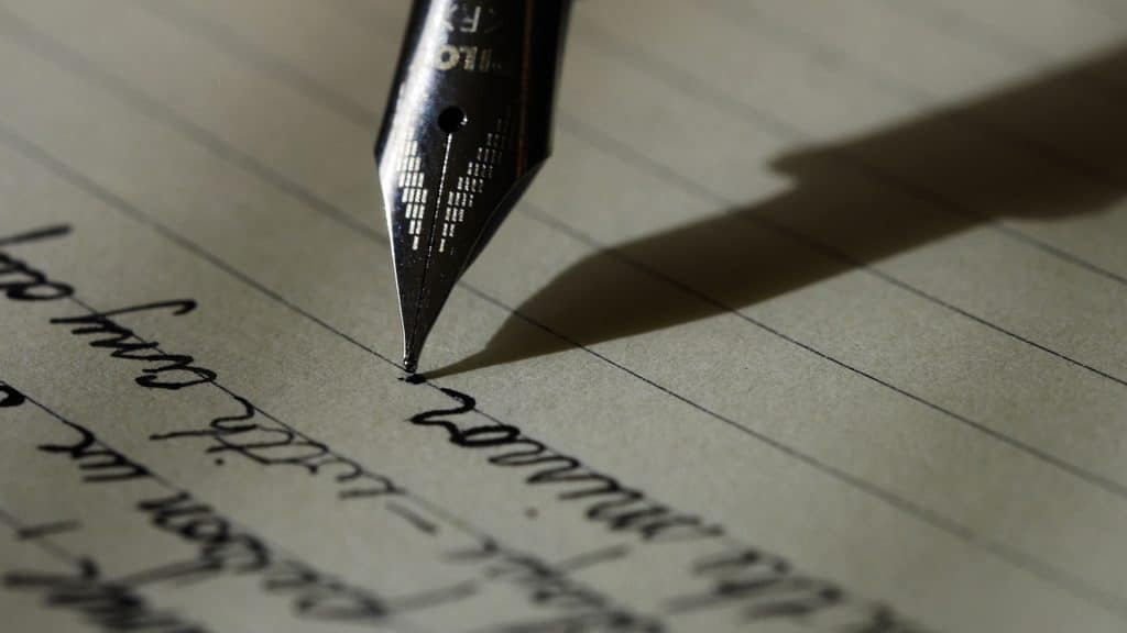 stylo à plume écrivant sur une feuille de papier